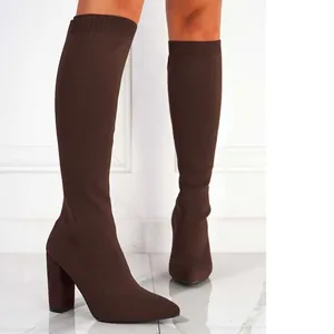 Elegant brown knitted stretch knee-high boots with chunky high heel and pointed toe.