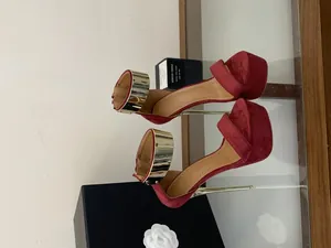 Close-up of burgundy platform sandals with gold metallic ankle straps