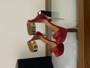 Close-up view of elegant burgundy suede platform sandals with gold 16cm stiletto heels