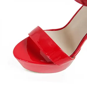Close-up of red patent leather platform sandal showing high gloss finish and stitching detail.