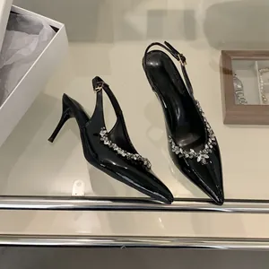Nahaufnahme von schwarzen Lackleder-Pumps mit funkelnden und eleganten Strassdetails.