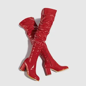 Red patent leather over-the-knee boots with chunky high heels and round toe design.