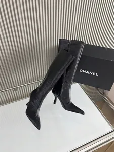Detailed view of black crocodile texture knee-high boots with pointed toe and high heel