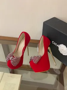 Detailed view of red platform stiletto heels with sparkling rhinestone bows