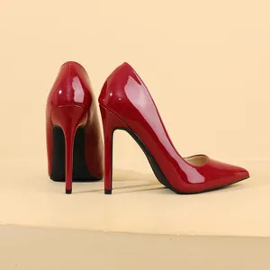 Detail view of red patent leather high heels with pointed toe and stiletto heels.