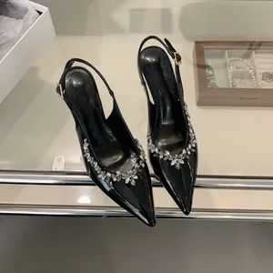 Detail von eleganten schwarzen Lackleder-Pumps mit spitzer Zehenpartie und Strassbesatz
