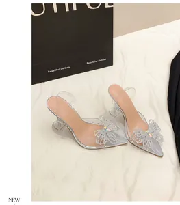Detailansicht klarer PVC-Pumps mit glitzernder Strass-Schleife und spitzer Kappe