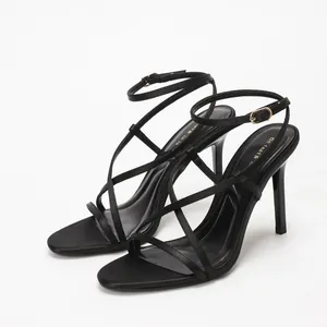 Elegant black satin high heel sandals with thin cross straps and ankle buckle closure