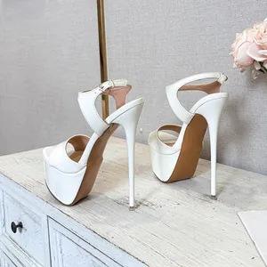 Elegant side view of white patent leather platform sandals with high stiletto heels