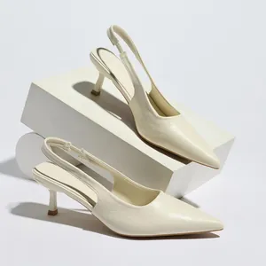 Close-up of elegant cream-colored pointed-toe slingback heels with kitten heels