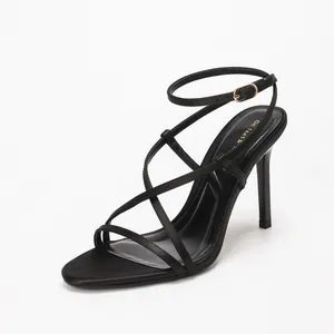 Elegant black satin high heel sandals featuring thin cross straps and ankle buckle.