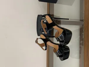 Détail des sandales à plateforme en cuir verni noir avec talons aiguilles sexy