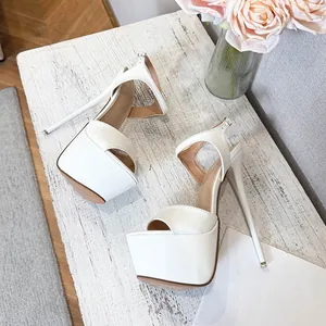 Detail of white platform high heel sandals with ankle straps on rustic wooden table