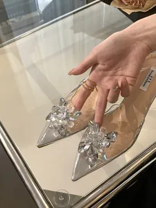 Gros plan de la fleur en strass étincelante sur escarpins argentés transparents