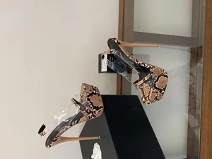 Macro view of snake print pattern and clear straps on platform stiletto sandals