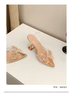 Detailansicht der funkelnden Strass-Schmetterlinge und eleganten Weinglas-Absätze.