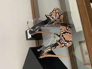 Macro view of snakeskin pattern and clear PVC straps on platform stiletto sandals