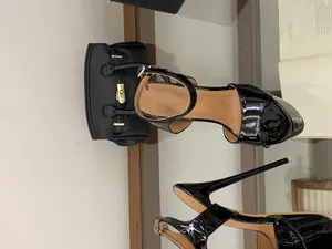 Détail du cuir verni noir brillant et du talon aiguille haut de ces sandales de soirée sexy