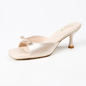 Elegant champagne satin mules for women featuring a stylish bow and kitten heel.