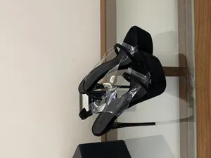 Detailed side view of black velvet platform stiletto sandals with clear PVC straps