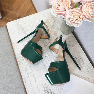 Detail of dark green patent leather platform stiletto sandals with ankle strap on white wood