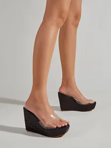 Detailweergave van glitterplateau-sandalen met transparante band en een hak van 10cm