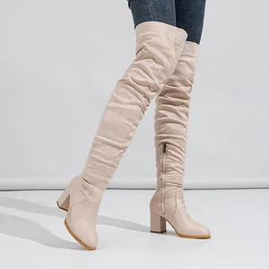 Fashionable beige suede over-the-knee slouch boots featuring chunky high block heels