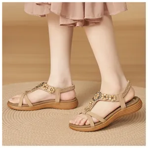 Close-up of comfortable beige Bohemian sandals featuring floral buckles and elastic heel straps