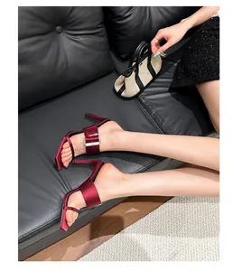 Elegant wine red stiletto sandals featuring a rhinestone buckle and trendy square toe design.