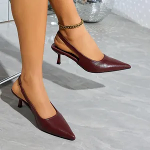Close-up of elegant maroon pointed-toe slingback kitten heels on model's feet.