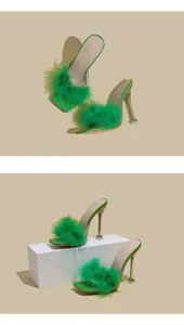 Detailed view of green stiletto heels featuring vibrant feather straps and a square toe.