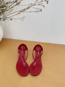 Detailed high-angle view of elegant red French style minimalist thong heeled sandals.
