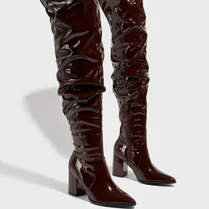 Pointed toe brown patent leather thigh-high boots with slouchy design and block heel