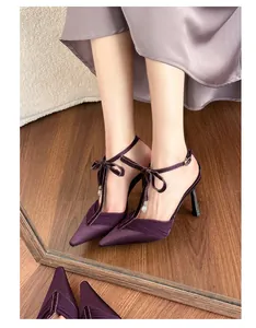 Detail view of elegant purple satin high heels with bow tie and dainty ankle strap
