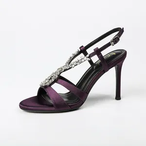 Elegant purple satin high heel sandals with rhinestone chain and ankle strap detail.