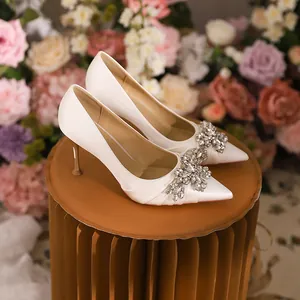 Elegant white pointed-toe high heels with sparkling rhinestone flower embellishment