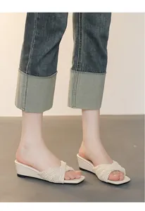 Vista laterale di eleganti sandali con zeppa intrecciati da donna con design a punta aperta.