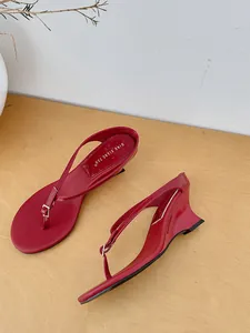 Side detail view of red minimalist wedge thong sandals with elegant thin straps for summer