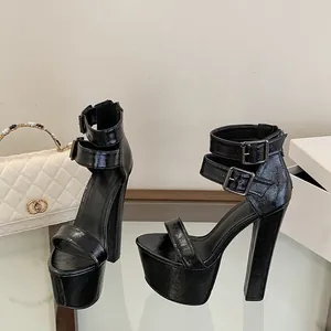 Detailaufnahme schwarzer Plateau-Sandalen aus Lackleder mit Blockabsatz und Schnallen.