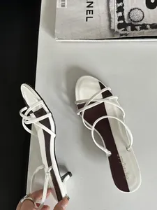 Vue détaillée de sandales blanches à fines brides et petits talons, design élégant