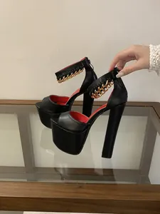 Side view of black platform sandals with chunky high heels and gold chain ankle strap