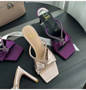 Detailed view of satin high heel sandals with sparkling rhinestone knot straps and square toe