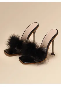 Detailed view of elegant black feather high heel sandals with transparent stilettos