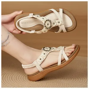 Close-up detail of beige bohemian sandals featuring flower buckle and elastic heel strap