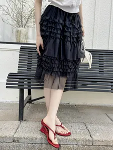 Close-up of minimalist red wedge thong sandals worn with a ruffled skirt