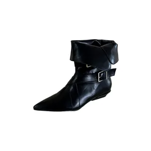 Close-up of black pointed-toe ankle boots featuring a chic fold-over cuff and buckle.