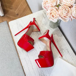Vibrant red high-heeled platform sandals displayed on a stylish white wooden table