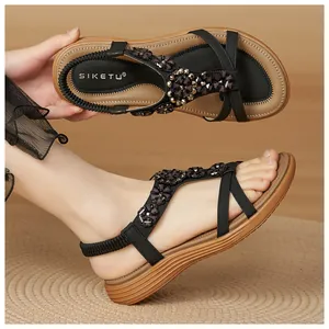 Close-up view of bohemian black sandals with beaded flower detail and elastic strap
