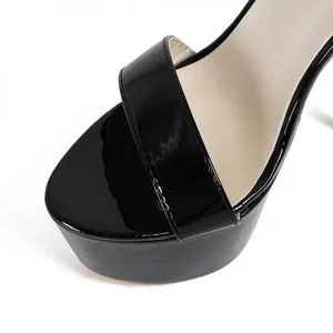Detailed close-up of a black patent leather platform sandal with high stiletto heel