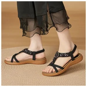 Bohemian black sandals with flower crystal buckles and elastic straps worn on feet